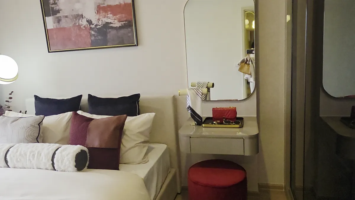 A residence bedroom with a red throw and a window.