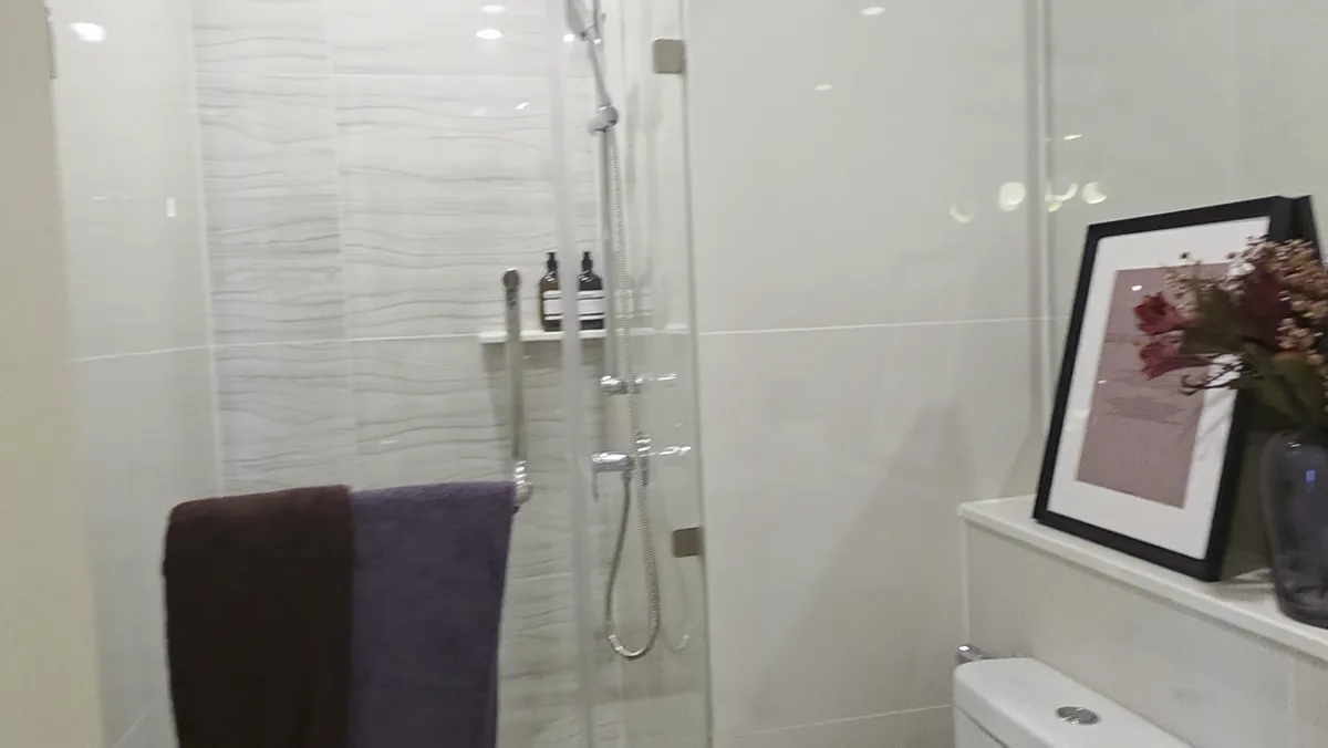 A bathroom vanity with a mirror and flowers.